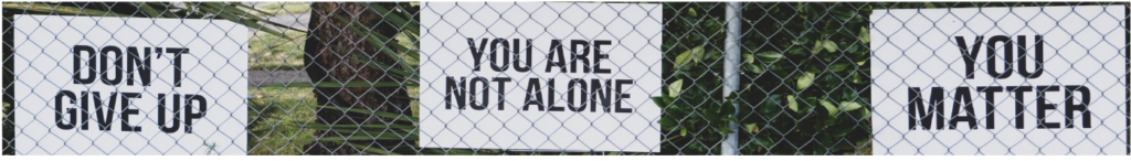 Tres carteles con las palabras "no te rindas", "no estás solo"; y "¿te importa?" En Inglés.